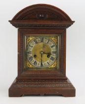 An Edwardian oak cased mantel clock, of arched outline, the 15cm brass dial with silvered chapter