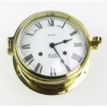 A Ship's lacquered brass bulkhead clock with 14cm Roman dial the movement striking ships bells,