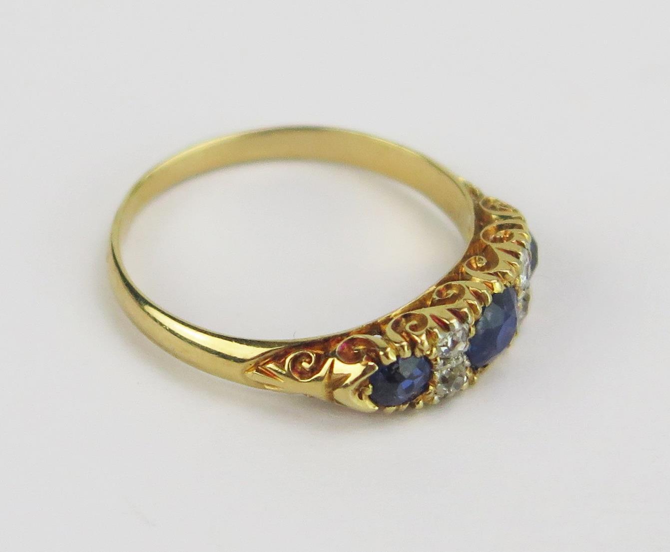An 18ct Gold, Sapphire and Diamond Ring with scrolling decoration to the shank, 4.2mm principal - Bild 2 aus 2