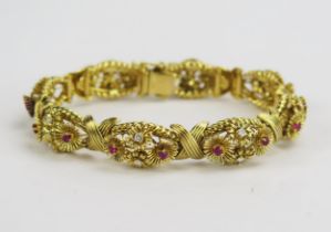 A 1950's 18ct Gold, Ruby and Diamond Bracelet decorated with eight panels having stones in