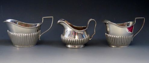 Three 20th century silver oval cream jugs, various makers and dates with half reeded decoration,
