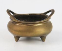 A Chinese circular bronze tripod censer, with swept loop handles, bears six character Xuande mark to