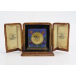 A 20th century French cloisonné travelling timepiece, the square case with 3cm circular brass