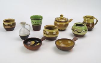 A collection of Winchcombe pottery slipware pots by S Tustin and C Tustin includes jugs, vases bowls