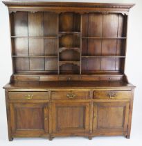 An 18th century oak dresser, the shelved superstructure with dentil moulded cornice, the base with