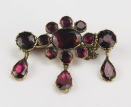 A Georgian Foil Backed Garnet Brooch in a precious yellow metal setting with three suspended pear
