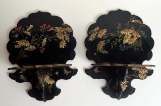 A pair of Victorian papier mache folding wall brackets, with floral decoration to a black ground,