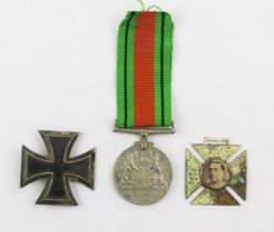 A Third Reich period Iron Cross 1st class, a Defence Medal and a Victoria commemorative cross.