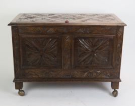 A reproduction carved oak coffer in the 17th century taste, the carved hinged lid with moulded