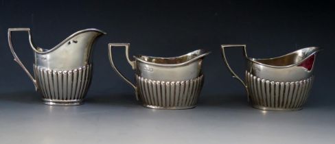 Three 20th century silver oval cream jugs, various makers and dates with half reeded decoration,