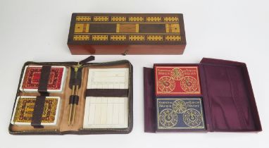 A mahogany folding cribbage board containing two packs of playing cards, Hoyle gaming counters,