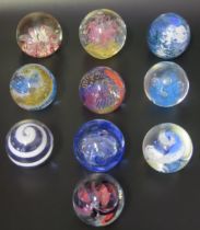A collection of twelve assorted glass paperweights, by various manufacturers, some boxed.