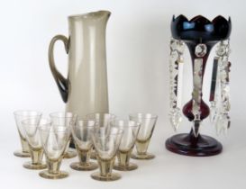 A Scandinavian smoked glass cordial jug with nine matching tumblers, together with a ruby glass
