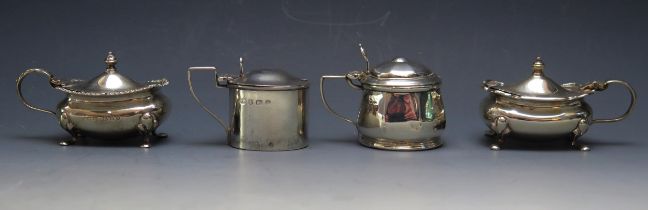 Four assorted 20th century silver lidded mustard pots, various makers and dates, all with blue glass