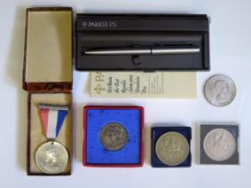 A Parker 25 ball-point pen, cased, together with commemorative medallions and crowns. and medallions