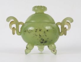 A Chinese jade carved circular tripod censer and cover, with flowerhead finial, with ring handles to