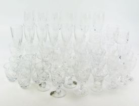 A collection of part suites of cut glass drinking vessels, including champagne flutes, wine glasses,