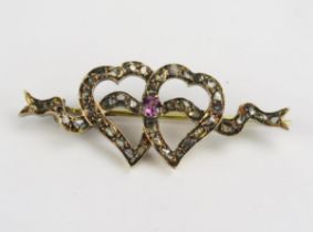 An Antique Rose Cut Diamond and Pink Stone Double Heart and Ribbon Decorated Brooch in a yellow