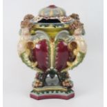 A German majolica vase and cover, the bowl with floral decoration supported by four cherubs,