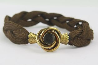 A Large Victorian Platted Hair Bracelet with chased yellow metal mounts and double sided locket,