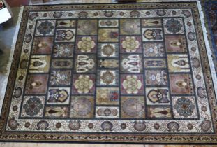 A Persian design carpet of panelled design with medallions and palmettes, enclosed by a triple