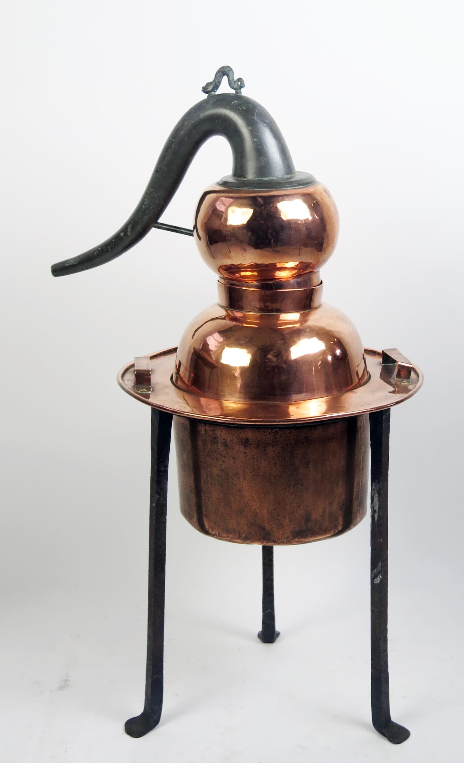 A 19th century French polished copper still, with swept metal spout, with cylindrical reservoir,