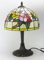 A Tiffany style table lamp, with leaded polychrome resin shade, on a fluted column and shaped