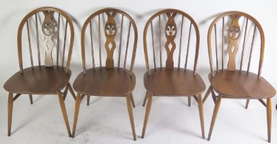 A set of four Ercol dining chairs, the oval backs with Prince of Wales feathers to the central