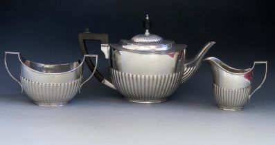 A matched three-piece tea service, various makers and dates, of oval outline with half reeded