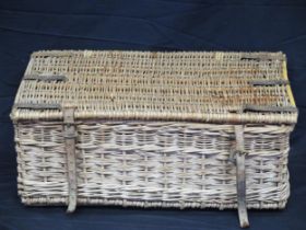 A wicker laundry hamper, with hinged lid and leather retaining straps, 70cm wide.