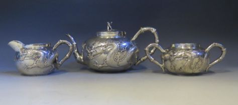 A Chinese silver three-piece tea service by Wang Hing & Co, Hong Kong, of cylindrical outline with