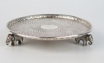 An Indian silver waiter, unmarked, of circular outline , with central roundel, raised on three