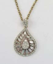 An 18ct Gold and Diamond Pendant set with baguette and brilliant round cuts, c. 24.8mm drop, stamped