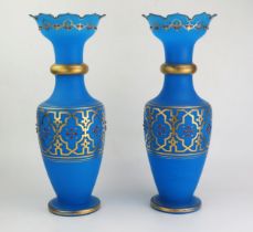 A pair of 19th century blue glass vases with flared rims, ring necks and ovoid bodies, on a circular