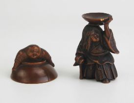 A Japanese carved boxwood netsuke depicting a man holding on to an upturned dish, unsigned, 4cm