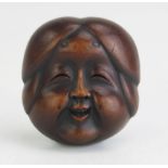 A Japanese carved boxwood netsuke of a female noh theatre mask, signed possibly Gyokushu, to the