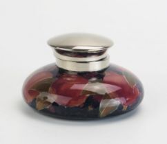 A Moorcroft pottery inkwell, with plated hinged lid and pomegranate decoration, 12cm diameter.