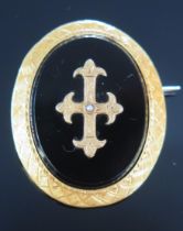 An Antique French 18ct Gold and Onyx Brooch with chased decoration and with a central cross with