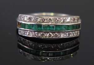 An Emerald and Diamond Ring in a precious white metal setting, the central c. 1.65mm square cut