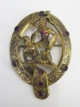 An Antique Yellow Metal Brooch depicting two battling knights in armour, 61x43mm