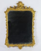 A carved gilt wood wall mirror, the rectangular mirror plate enclosed by an arched frame with