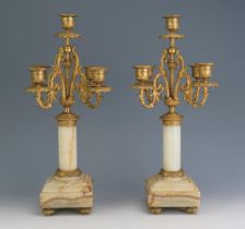 A pair of 19th century alabaster, marble and ormolu five light candelabra with urn-shaped sconces on