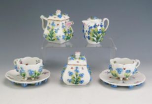 A German porcelain miniature bachelors tea set with moulded applied forget-me-not decoration,