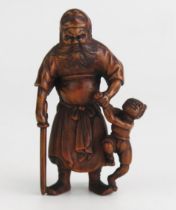 A Japanese carved okimono of Shoki the demon queller, the standing figure with oni in one hand and a