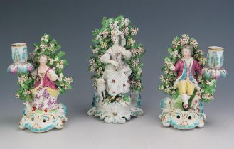 A pair of late 19th century figural porcelain candle holders, of s seated gallant and lady each