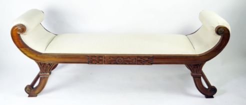 A reproduction carved hardwood window seat in the regency taste, with padded scroll ends and