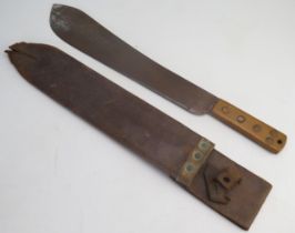 A World War II period machete, with 37.5cm blade, with wood grip, in leather sheath, faintly stamped