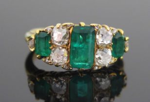 An Emerald and Diamond Ring in a precious yellow metal setting, c. 8.18x4.55mm principal stone