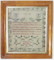 A William IV needlework sampler with central verse, angels, flowering shrubs, enclosed by a floral