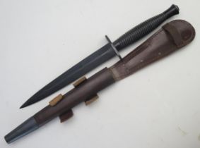 A Fairbairn Sykes third pattern fighting knife, with blackened double edge blade and ribbed grip,